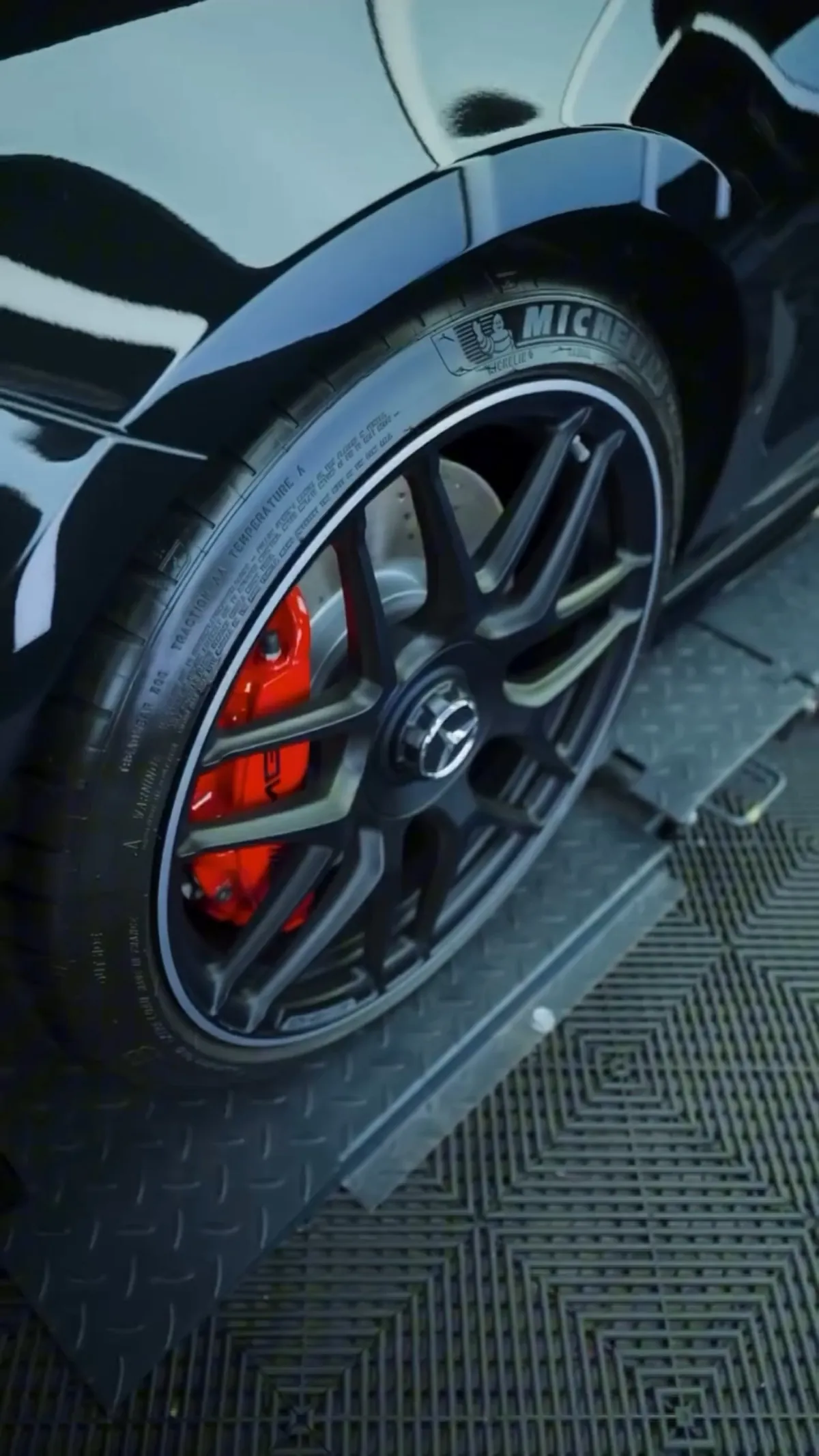 Clean black alloy wheel with a red brake caliper